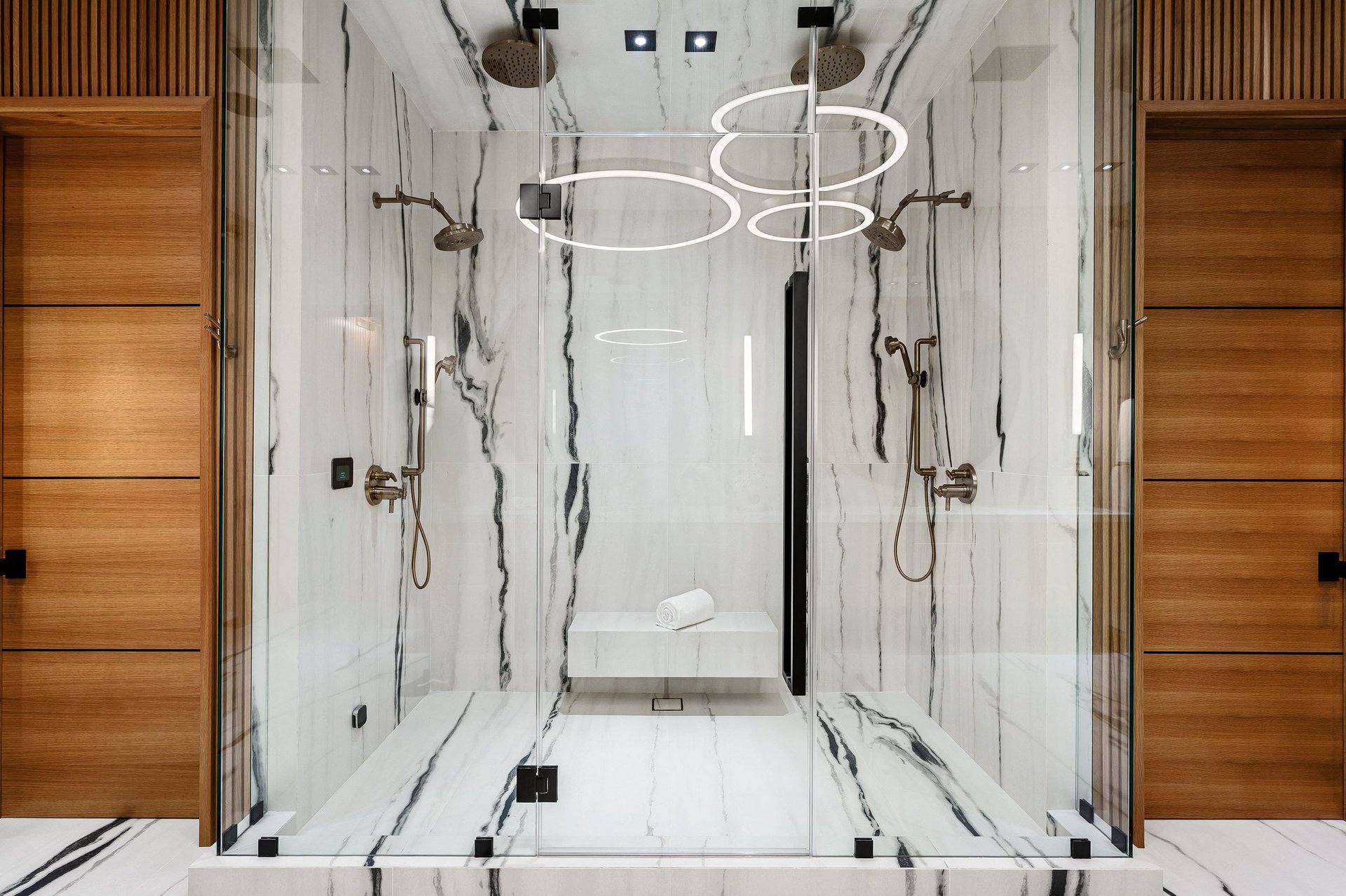 Luxurious modern bathroom with marble walls and glass shower enclosure