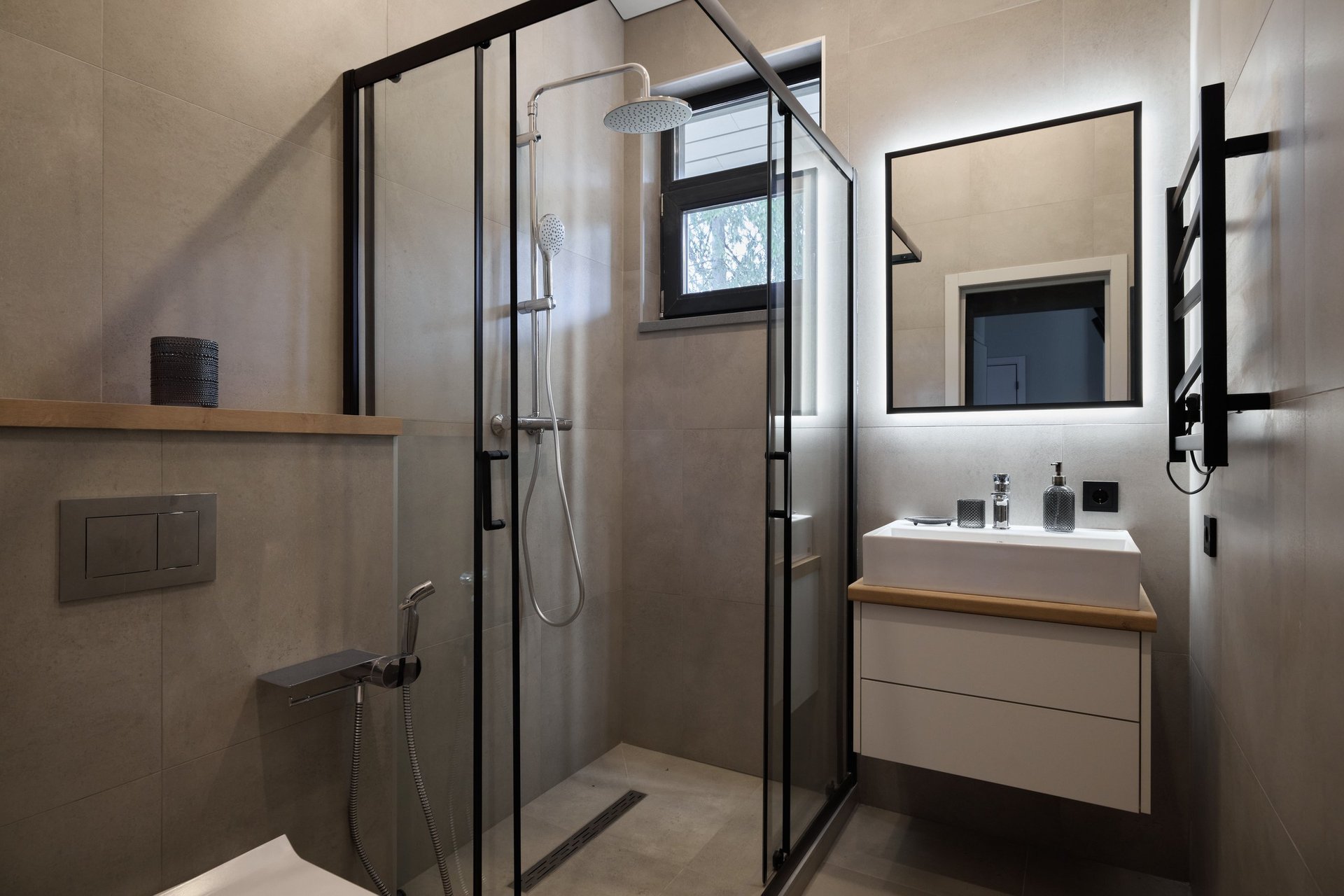 The stylish minimalist bathroom showcases a sleek glass shower alongside modern, high-quality fixtures