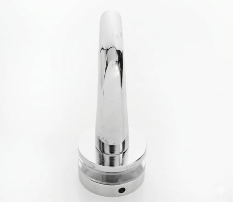Modern chrome and white electronic device with elongated cone shape and circular metallic base on neutral background