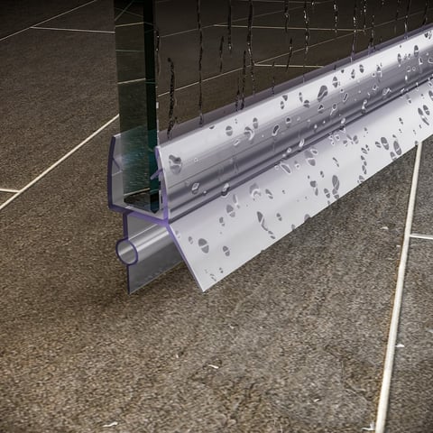 Close-up of a weatherstrip or seal component attached to a metal rail or door frame on concrete ground