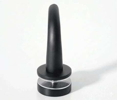 Black conical-shaped object with clear glass base ring on white background